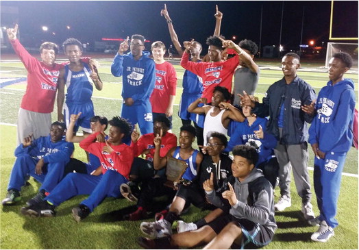 The Marion Junior High track team celebrates it’s 6A-East district title last week.